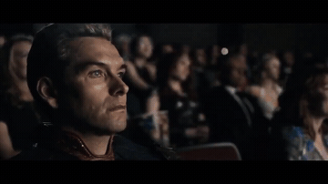 Add text to the Homelander Watching a Movie reaction GIF template in Memesio. Set width, trim the 5.0 second clip, and make a share-ready GIF meme.